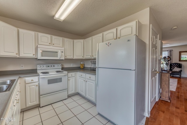 147 Rainbow Cir Unit 147, Bristol, VA 24202 - kitchen with white appliances, white cabinets, and a textured ceiling
