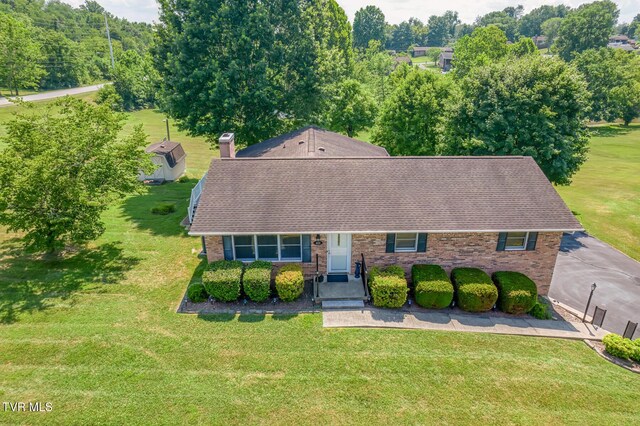 409 Brooklea Cir, Bluff City, TN 37618 - view of front facade with a shingled roof, brick siding, a front yard, and a chimney