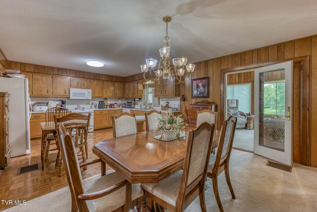 409 Brooklea Cir, Bluff City, TN 37618 - dining space with plenty of natural light, a chandelier, a textured ceiling, and wooden walls