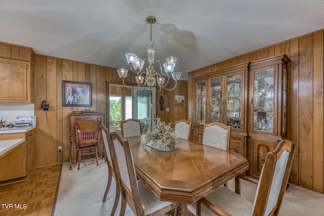 409 Brooklea Cir, Bluff City, TN 37618 - dining room featuring wooden walls, a chandelier, and a textured ceiling