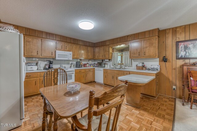 409 Brooklea Cir, Bluff City, TN 37618 - kitchen featuring white appliances, light countertops, wood walls, a textured ceiling, and brown cabinetry