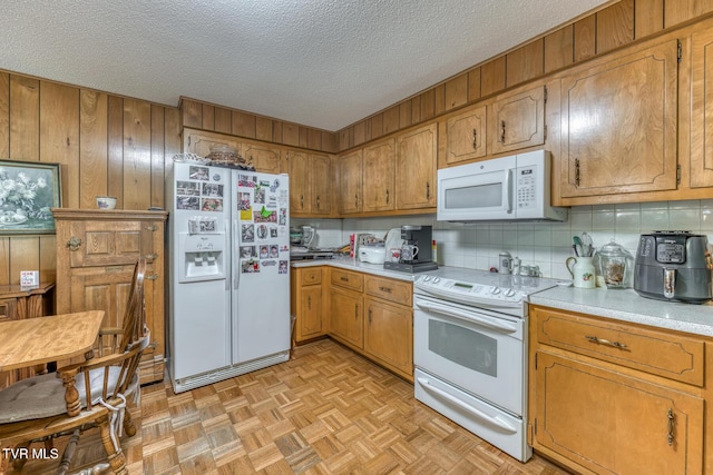 409 Brooklea Cir, Bluff City, TN 37618 - kitchen featuring white appliances, light countertops, wood walls, brown cabinets, and a textured ceiling