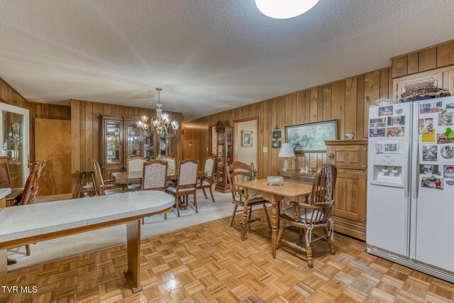 409 Brooklea Cir, Bluff City, TN 37618 - dining room featuring wooden walls, a textured ceiling, and a chandelier