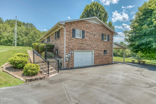 409 Brooklea Cir, Bluff City, TN 37618 - view of side of property with an attached garage, asphalt driveway, brick siding, and a lawn