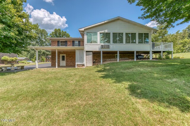 409 Brooklea Cir, Bluff City, TN 37618 - back of property with brick siding, a lawn, a sunroom, and a wooden deck