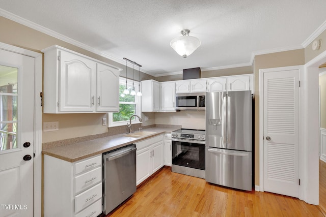 308 Cardinal Ln, Bristol, TN 37620 - kitchen with appliances with stainless steel finishes, crown molding, white cabinetry, light countertops, and light wood-style flooring