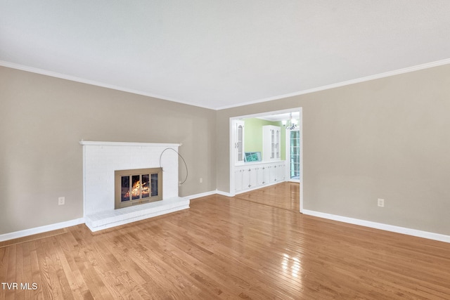 308 Cardinal Ln, Bristol, TN 37620 - unfurnished living room featuring wood finished floors, a chandelier, crown molding, and a brick fireplace