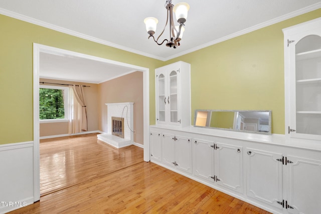 308 Cardinal Ln, Bristol, TN 37620 - unfurnished dining area with a chandelier, light wood finished floors, crown molding, and a fireplace