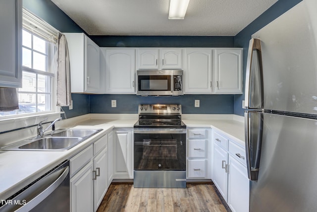 152 Gray Station Rd Unit 35, Gray, TN 37615 - kitchen featuring appliances with stainless steel finishes, plenty of natural light, white cabinetry, light wood-style flooring, and a textured ceiling
