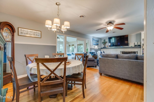 312 Timberlane Rd, Bristol, TN 37620 - dining area featuring a brick fireplace, ceiling fan, light wood-type flooring, and a chandelier