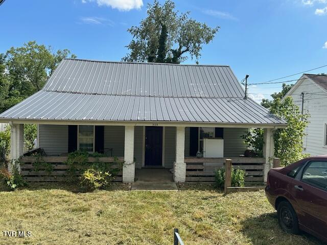 938 Barker St, Bristol, TN 37620 - view of front of home with covered porch, a metal roof, and a front lawn