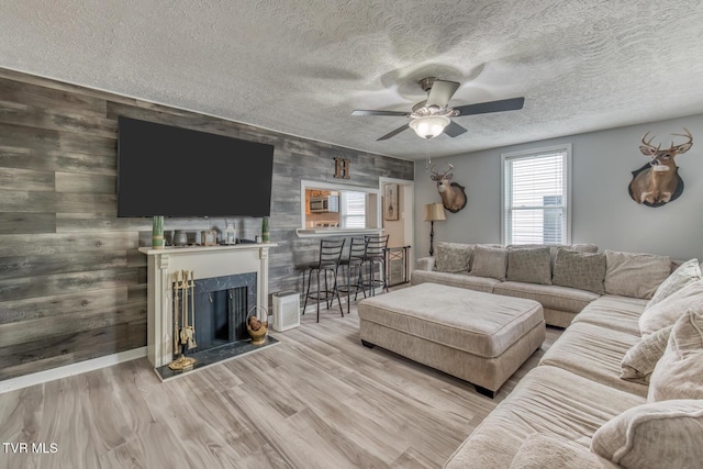 218 Kirkwood St, Glade Spring, VA 24340 - living area with plenty of natural light, a ceiling fan, wooden walls, wood finished floors, and a premium fireplace