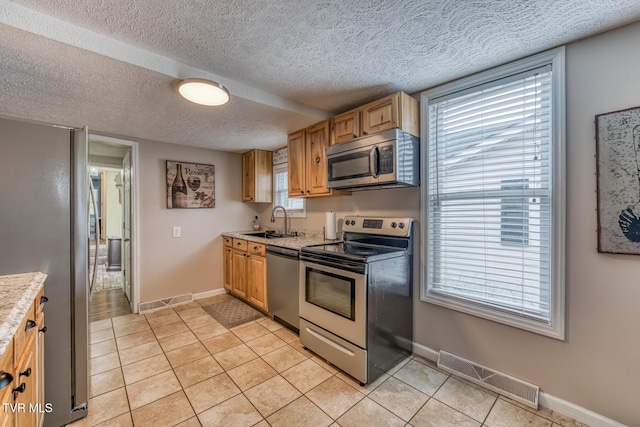 218 Kirkwood St, Glade Spring, VA 24340 - kitchen with appliances with stainless steel finishes, light countertops, light tile patterned flooring, and a textured ceiling