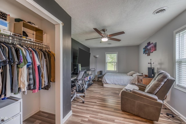 218 Kirkwood St, Glade Spring, VA 24340 - bedroom featuring wood finished floors, a textured ceiling, a desk, a ceiling fan, and a closet