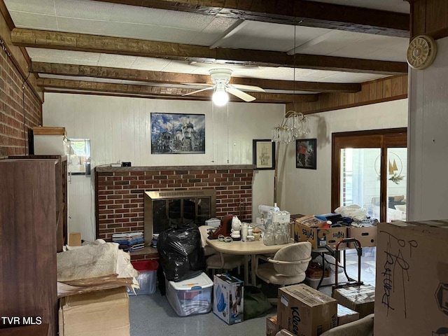 2818 Dungannon Rd, Coeburn, VA 24230 - living area with ceiling fan, beamed ceiling, a brick fireplace, wooden walls, and concrete flooring