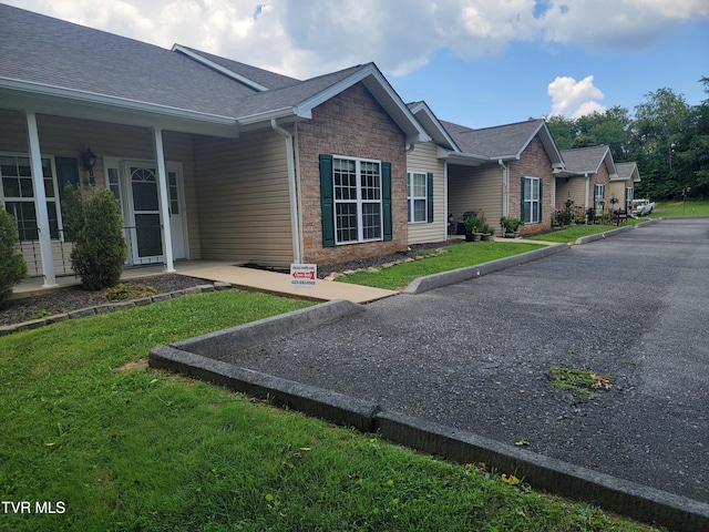 63 Whisper Bnd Unit 1, Johnson City, TN 37604 - view of side of property featuring roof with shingles, a lawn, and brick siding