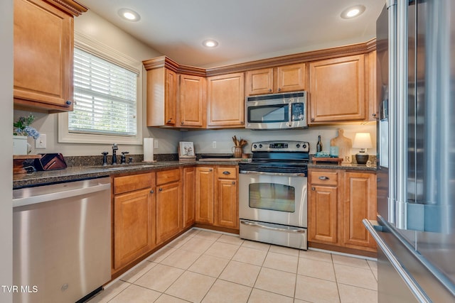 417 Piper Gln, Gray, TN 37615 - kitchen featuring appliances with stainless steel finishes, light tile patterned floors, recessed lighting, dark stone countertops, and brown cabinets
