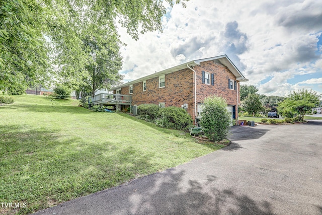 107 Dover Ln, Bristol, TN 37620 - view of side of property with brick siding, asphalt driveway, a yard, an attached garage, and a wooden deck
