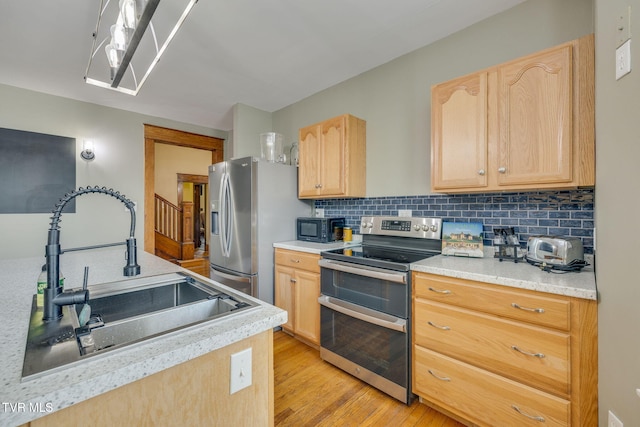 522 Alabama St, Bristol, TN 37620 - kitchen with appliances with stainless steel finishes, light brown cabinetry, light wood-style flooring, backsplash, and light countertops
