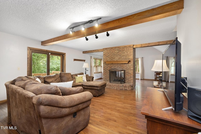 2019 Ridgeview Dr, Big Stone Gap, VA 24219 - living room featuring light wood-style flooring, a textured ceiling, a fireplace, and beamed ceiling