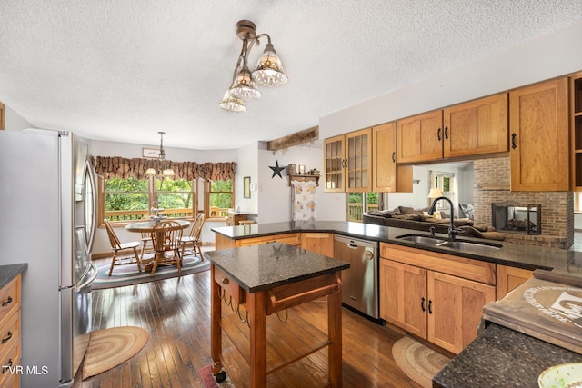 2019 Ridgeview Dr, Big Stone Gap, VA 24219 - kitchen featuring appliances with stainless steel finishes, a textured ceiling, a peninsula, decorative light fixtures, and dark wood-style flooring