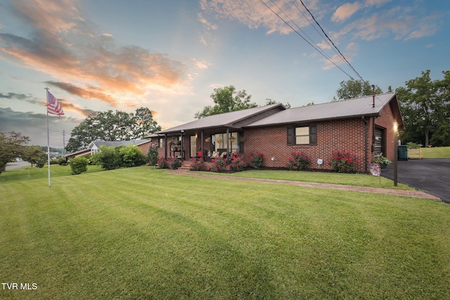 188 Mcarthur Cir, Bristol, VA 24201 - view of front of house with a front lawn, brick siding, a metal roof, an attached garage, and driveway