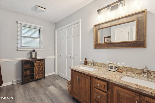 188 Mcarthur Cir, Bristol, VA 24201 - bathroom featuring wood finished floors, double vanity, and a textured ceiling