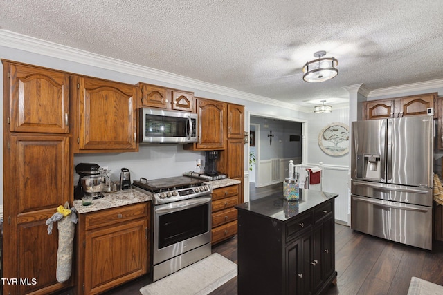 188 Mcarthur Cir, Bristol, VA 24201 - kitchen with stainless steel appliances, crown molding, brown cabinets, a textured ceiling, and a wainscoted wall