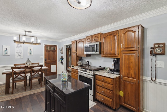 188 Mcarthur Cir, Bristol, VA 24201 - kitchen with stainless steel appliances, dark wood-style flooring, ornamental molding, a textured ceiling, and brown cabinetry