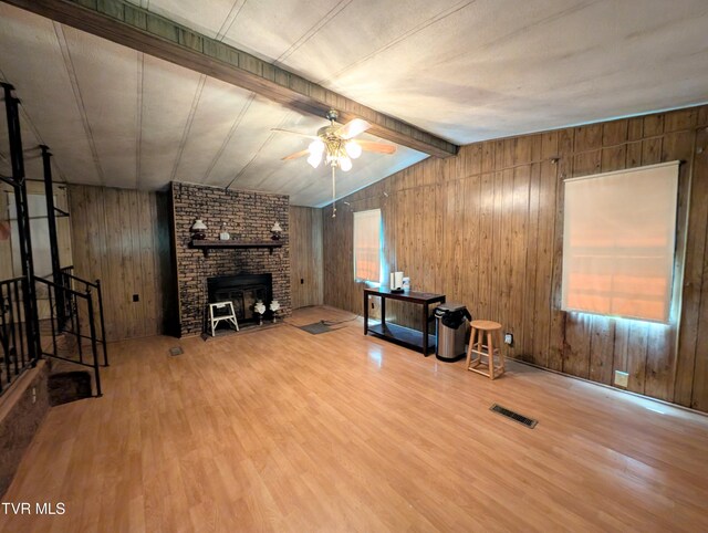 222 Warren Dr, Big Stone Gap, VA 24219 - unfurnished living room featuring wooden walls, wood finished floors, ceiling fan, and a fireplace