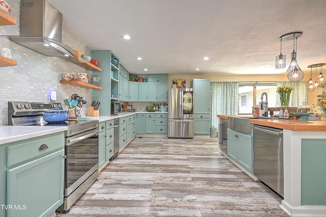 1108 Glen St, Bristol, TN 37620 - kitchen featuring stainless steel appliances, wall chimney range hood, open shelves, light wood-type flooring, and recessed lighting