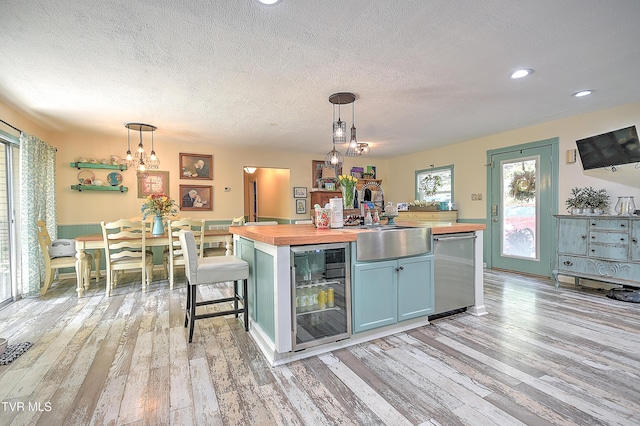 1108 Glen St, Bristol, TN 37620 - kitchen with butcher block counters, beverage cooler, a textured ceiling, light wood-type flooring, and a kitchen island