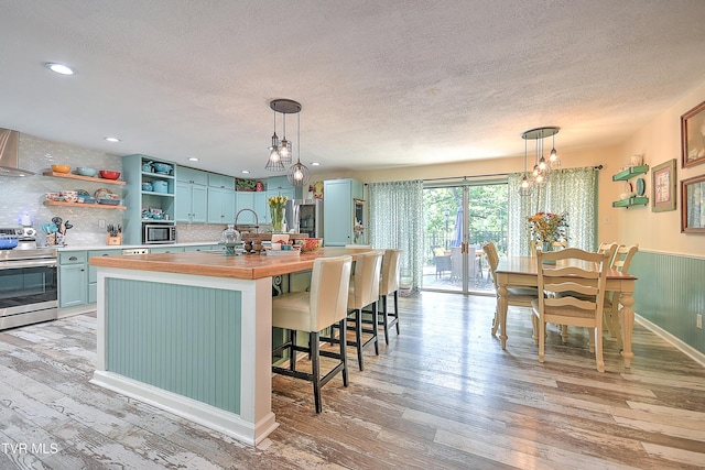 1108 Glen St, Bristol, TN 37620 - kitchen with appliances with stainless steel finishes, butcher block counters, light wood-style flooring, open shelves, and blue cabinets