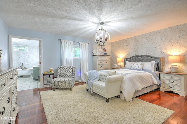 1108 Glen St, Bristol, TN 37620 - bedroom featuring hardwood / wood-style flooring, an accent wall, multiple windows, wallpapered walls, and a textured ceiling