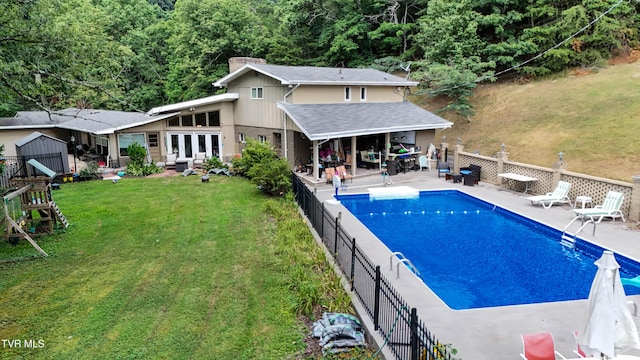 1108 Glen St, Bristol, TN 37620 - view of swimming pool featuring a patio, a storage unit, and a view of trees