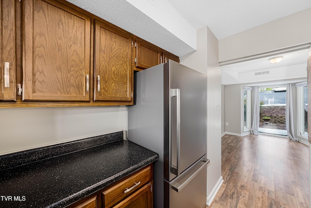 182 Sierra Pl Unit 182, Bristol, VA 24201 - kitchen with freestanding refrigerator, wood finished floors, brown cabinets, and dark stone counters