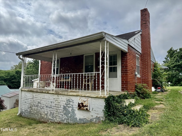 121 Mull St, Kingsport, TN 37665 - view of side of property with a chimney, covered porch, and brick siding