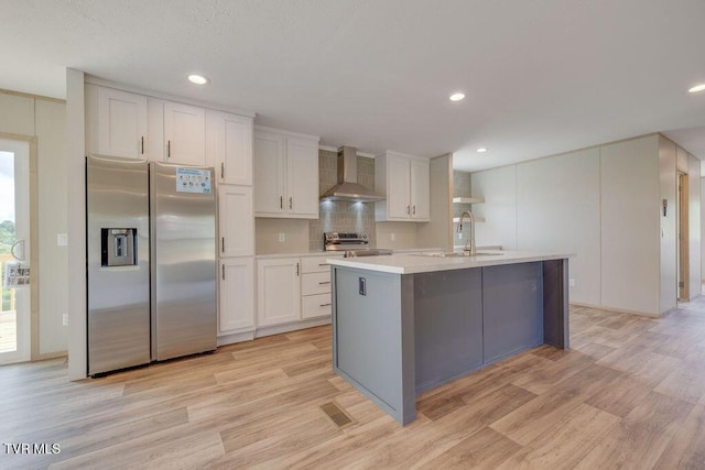 106 Iris Ln, Fall Branch, TN 37656 - kitchen with stainless steel appliances, wall chimney exhaust hood, white cabinetry, light wood finished floors, and recessed lighting