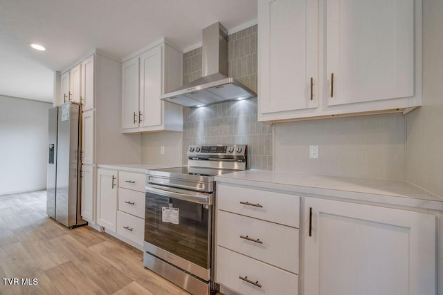 106 Iris Ln, Fall Branch, TN 37656 - kitchen with stainless steel appliances, wall chimney exhaust hood, light countertops, decorative backsplash, and light wood-style floors