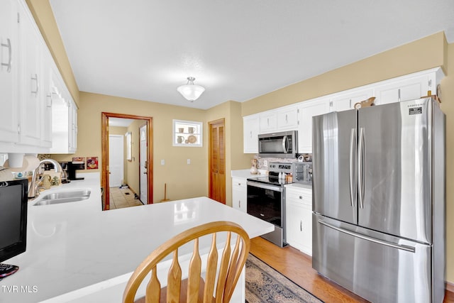 520 Lyle Rd, Erwin, TN 37650 - kitchen with stainless steel appliances, light countertops, white cabinets, and a peninsula