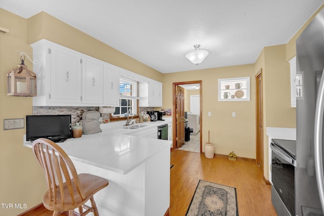 520 Lyle Rd, Erwin, TN 37650 - kitchen featuring electric range oven, freestanding refrigerator, a peninsula, light countertops, and white cabinetry