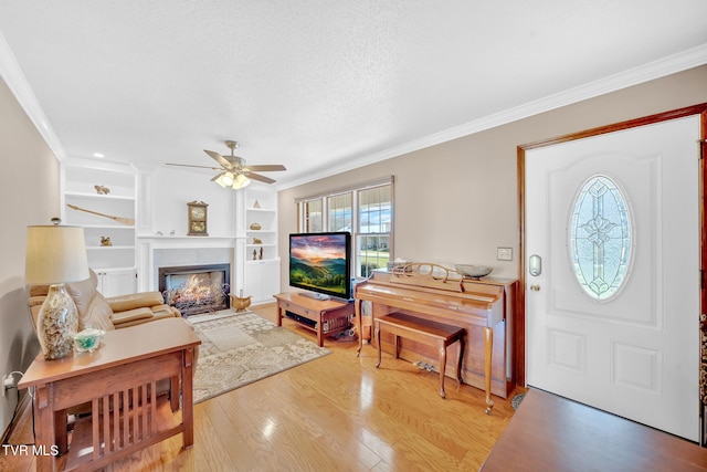 520 Lyle Rd, Erwin, TN 37650 - foyer entrance featuring a ceiling fan, crown molding, light wood-style floors, and a fireplace with flush hearth