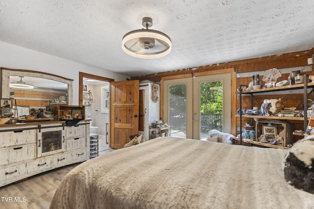 2169 Ranch Rd, Dandridge, TN 37725 - bedroom featuring french doors, wood finished floors, access to exterior, a textured ceiling, and ensuite bath