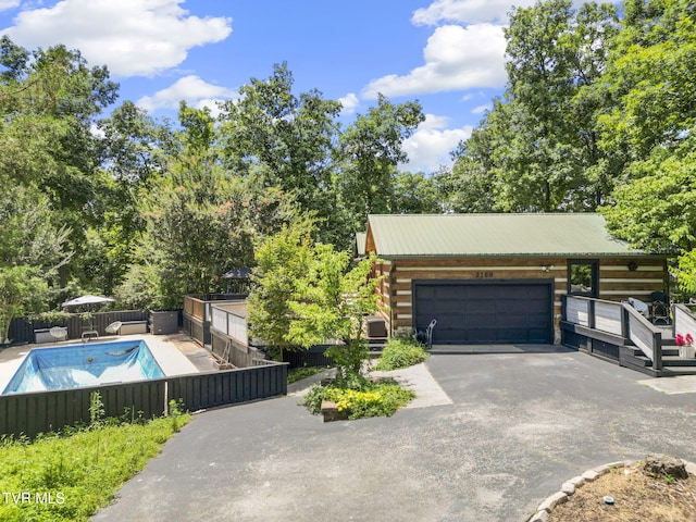 2169 Ranch Rd, Dandridge, TN 37725 - view of front facade featuring log exterior, asphalt driveway, a metal roof, and an attached garage
