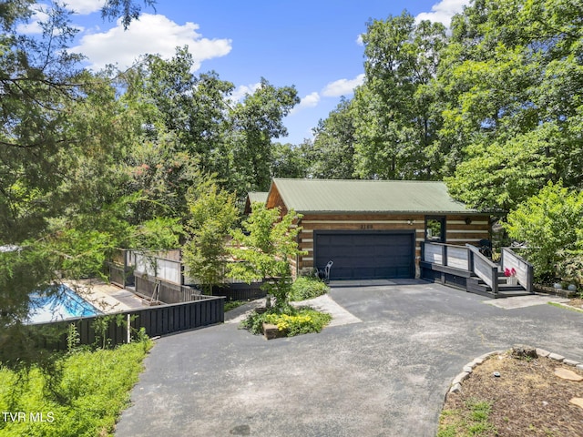 2169 Ranch Rd, Dandridge, TN 37725 - view of front of home featuring asphalt driveway, a metal roof, an attached garage, and log siding