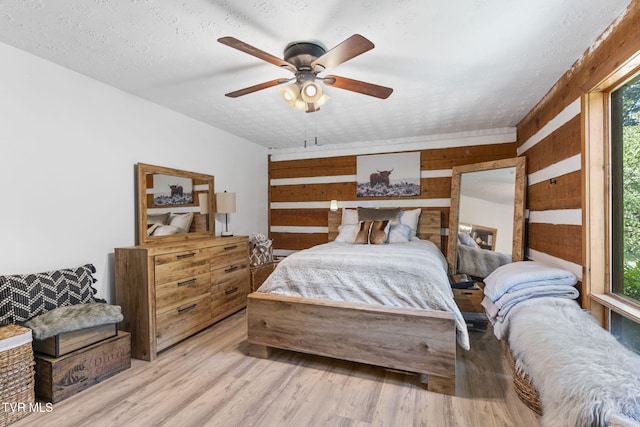2169 Ranch Rd, Dandridge, TN 37725 - bedroom with light wood-type flooring, wood walls, and a ceiling fan