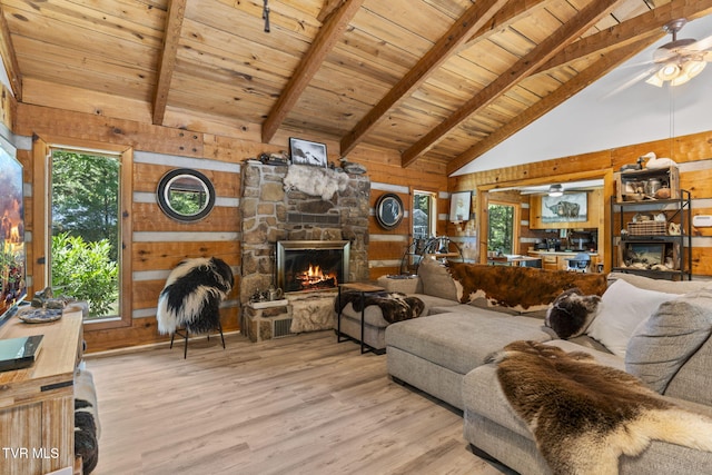 2169 Ranch Rd, Dandridge, TN 37725 - living room featuring wood walls, a stone fireplace, healthy amount of natural light, a wooden ceiling with exposed beams, and high vaulted ceiling