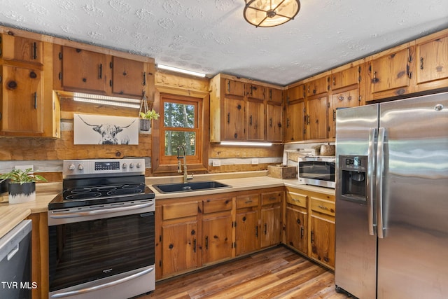 2169 Ranch Rd, Dandridge, TN 37725 - kitchen with appliances with stainless steel finishes, light countertops, brown cabinets, light wood finished floors, and a textured ceiling