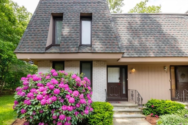 10 Grove Sq Unit 10, Randolph, MA 02368 - view of exterior entry with roof with shingles and brick siding