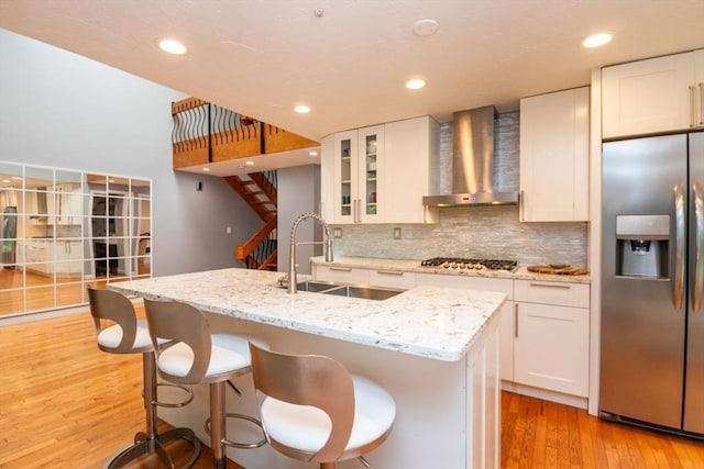 10 Grove Sq Unit 10, Randolph, MA 02368 - kitchen with stainless steel appliances, wall chimney exhaust hood, a sink, light wood-style flooring, and tasteful backsplash